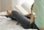 一個女生躺在床上看書