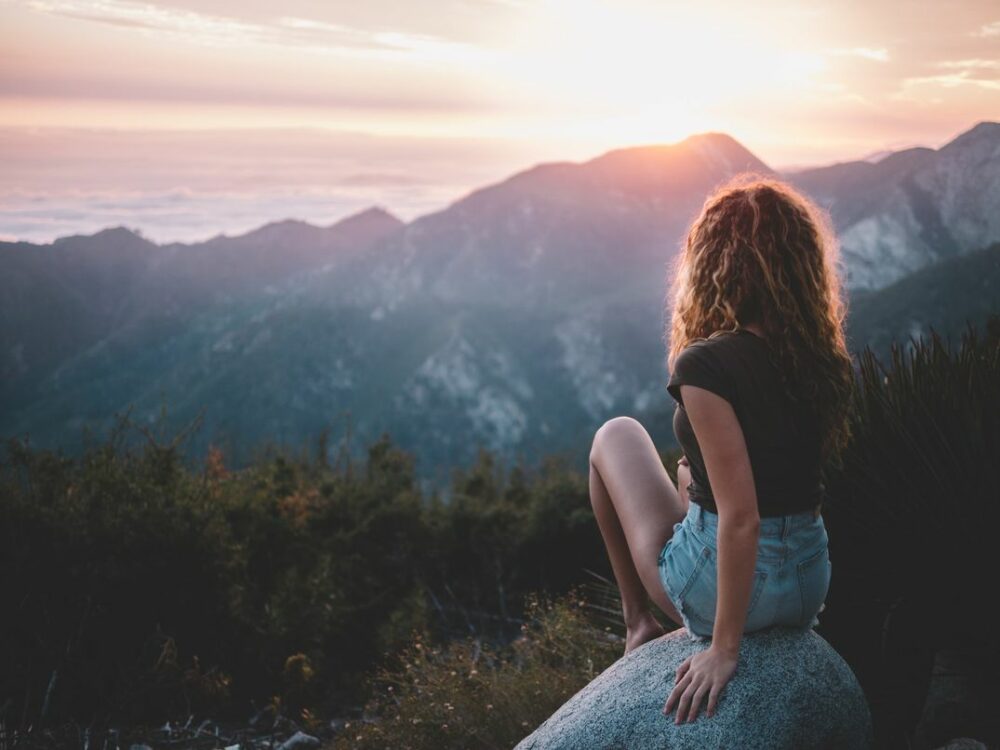 一個女生在山上看日出