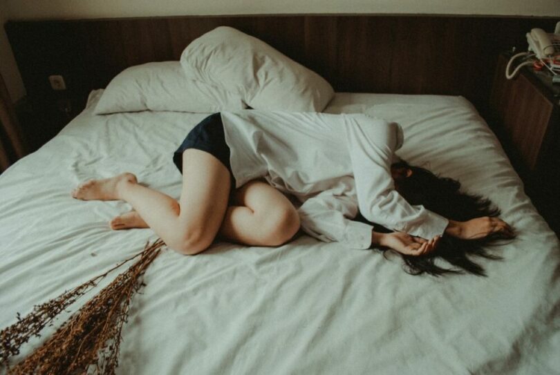 一個女生不舒服躺在床上