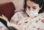 一個女生戴著口罩在看書