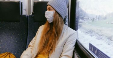 一個女生戴著口罩搭火車