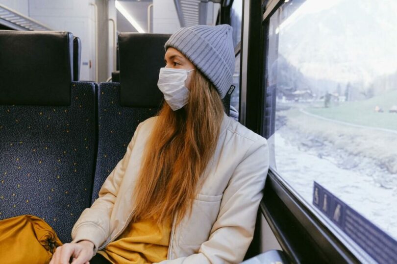 一個女生戴著口罩搭火車