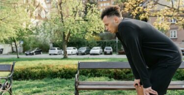 一個男人在公園旁半蹲握住膝蓋