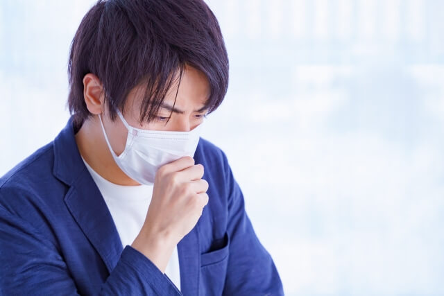 一位男性戴口罩咳嗽