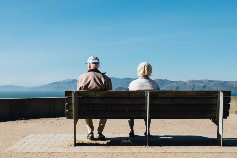 兩個老人坐在椅子上看風景