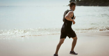 一個男人在沙灘上跑步
