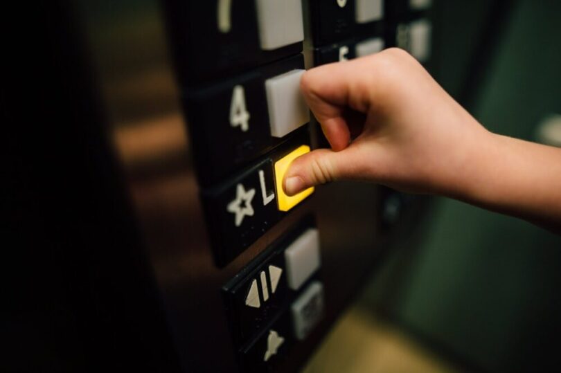 用拇指按電梯樓層按鈕